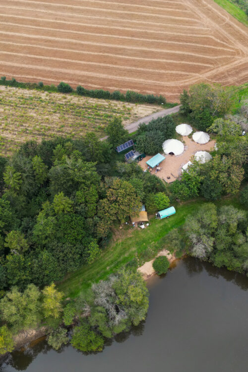 Aerial view of trees surrounding white tents.