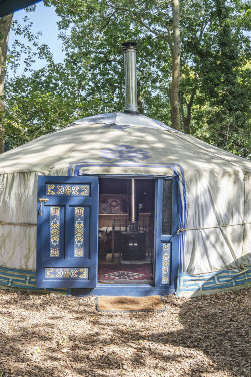 White yurt with an open blue painted door.
