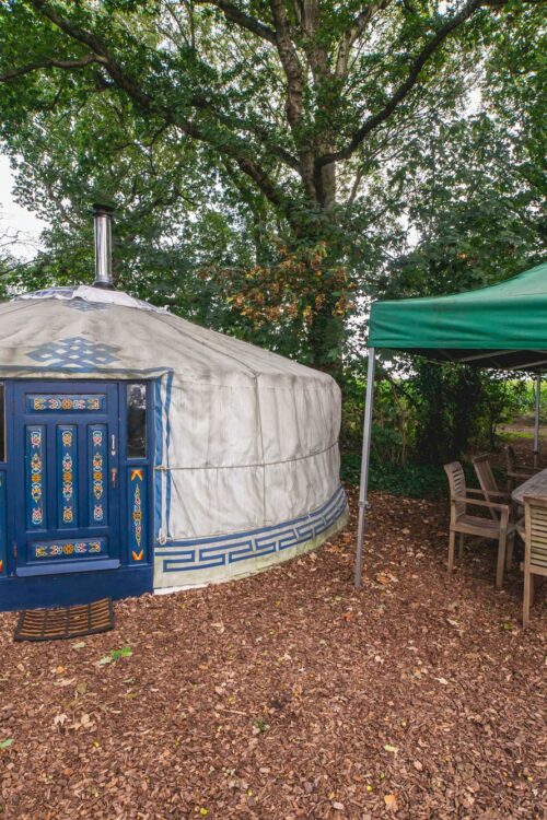 White yurt with a large blue door.